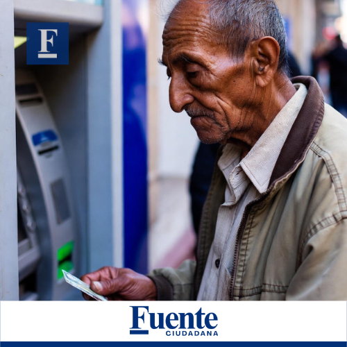 Un hombre indígena de edad avanzada, con arrugas profundas y cabello despeinado, mira con atención la pantalla de un cajero automático mientras introduce una tarjeta. Viste una camisa a cuadros clara y una chaqueta de color caqui