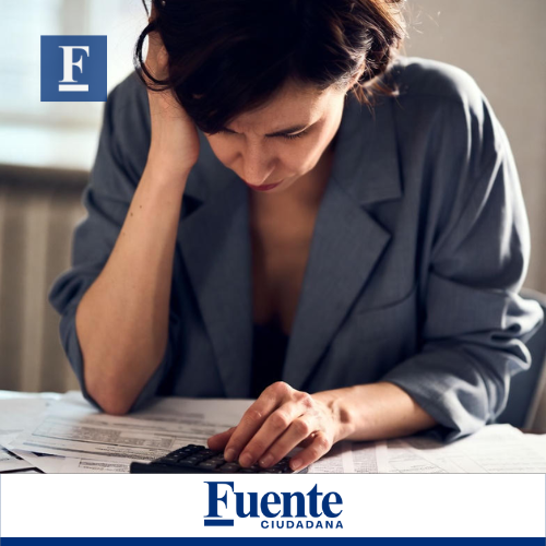 Persona preocupada frente a su celular por no haber pagado un crédito bancario